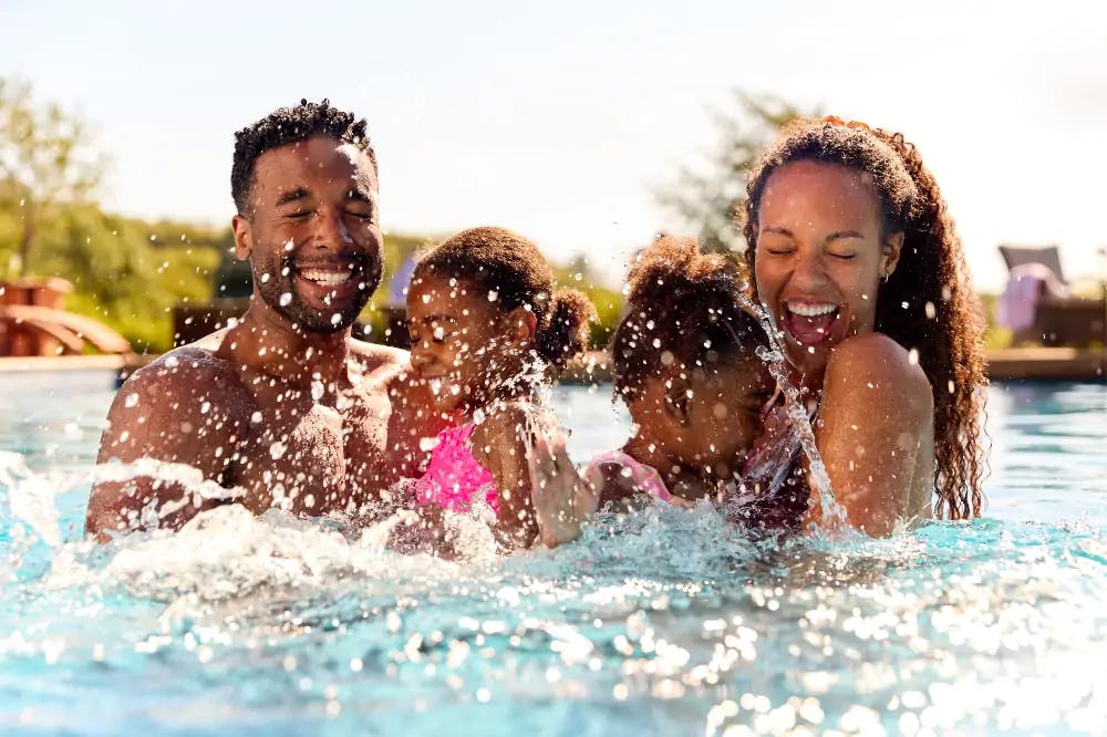 black family splashing in their swimming pool